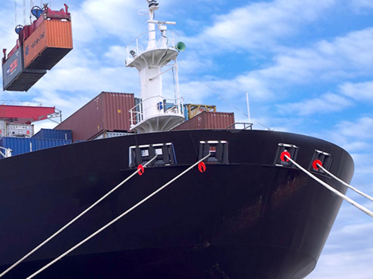 Shipping container lifted by crane from a ship